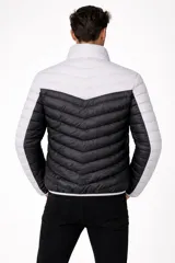 Campera acolchada de nylon con diseño color block. La parte superior del torso y los hombros son de color beige claro, mientras que el cuerpo principal y la parte inferior de las mangas son de color verde oliva. Posee cuello alto y cierre frontal.