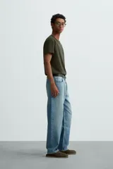 Camiseta de algodón de peso medio, color gris oscuro con efecto lavado ligero. Presenta cuello redondo y manga corta.