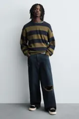 Zapatillas bajas de lona negra con cordones blancos y suela de goma blanca con textura.