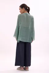 Camisa azul con cuello mao, abotonada al frente y mangas largas.