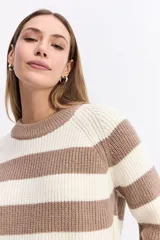 Buzo de punto con diseño de rayas horizontales anchas en color negro y celeste. Presenta cuello redondo, mangas largas y un corte holgado con terminaciones acanaladas.