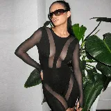 Enterizo negro ajustado de mangas largas, con transparencias en el frente, laterales y piernas.