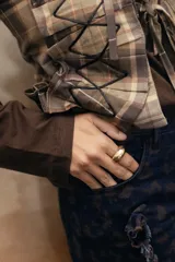Anillo de diseño orgánico con pieza ovalada color dorado y estructura abierta.