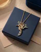 Collar de bronce dorado con cadena fina y dije en forma de colibrí esmaltado en tonos celestes y negros, con incrustaciones de circonias y un ojo turco en el centro.