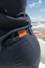 Pantalón de lino negro con tiro medio, corte recto y aberturas laterales en el dobladillo inferior.