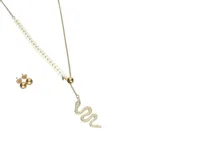 Set de collar y caravanas doradas. El collar es de acero con baño de oro estilo corbatero y dije de serpiente con circonias. Las caravanas son doradas con forma de esfera.