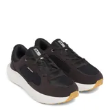 Championes Under Armour modelo Versurge, color gris oscuro con detalles en negro. Presentan una combinación de malla y revestimientos de gamuza sintética, con entresuela blanca de tecnología Charged Cushioning y suela de goma color caramelo.