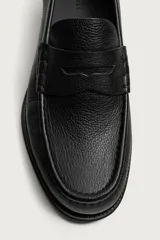 Mocasín de vestir para hombre confeccionado en piel con acabado abatanado, de color marrón. Cuenta con detalle de antifaz en el empeine, horma redonda, plantilla interior de piel y suela a contraste con ligero tacón.