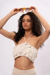 Top tejido a crochet color crudo, con diseño de flores en relieve y tirantes finos.