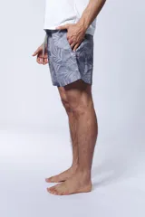 Short de baño celeste con estampado de hojas de palmera en gris.