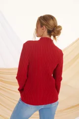 Sweater rojo de punto acanalado, con cuello alto y mangas largas.