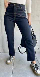 Pantalón de jean negro con costuras a la vista color ocre.