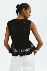 Top negro sin mangas de punto estilo crochet, con cuello redondo, cierre oculto en la espalda y diseño de peplum acampanado con ribetes festoneados.