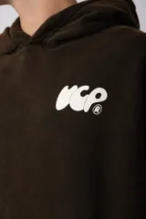 Buzo canguro oversize de algodón frisa premium con efecto lavado en color negro. Presenta capucha, bolsillo frontal tipo canguro y estampa blanca en el pecho.