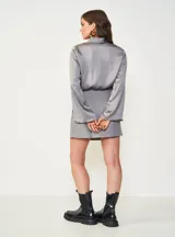 Camisa gris de satén con cuello camisero y mangas largas con puños acampanados.