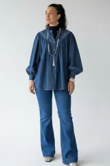 Jean de tiro alto en denim azul, con corte ajustado en la parte superior y botamanga ligeramente acampanada.