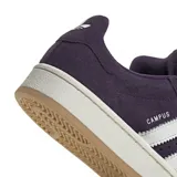 Championes Adidas modelo Campus 00s, color violeta oscuro con las icónicas tres tiras laterales en blanco. Presentan una silueta clásica de perfil bajo, confeccionados en gamuza con suela de goma en tono claro.