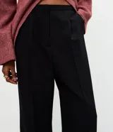 Pantalón de sastrería color negro, de corte recto, con pretina fina, pinzas frontales y bolsillos.