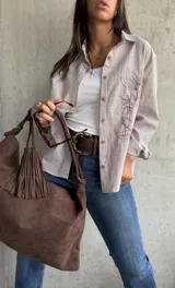 Camisa clásica a rayas verticales blancas y tostadas, con botones marrones y bordado floral en el frente.