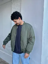 Campera bomber verde militar de nylon con cierre frontal y bolsillos laterales.