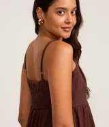 Vestido midi de Blue Steel confeccionado en sarga de algodón, con diseño de corte amplio, escote recto y breteles finos. Presenta una falda con cortes horizontales que aportan volumen y movimiento.