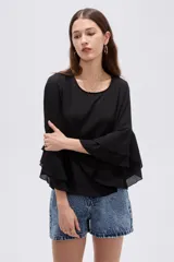 Blusa negra de poliéster, con cuello redondo, mangas 3/4 con volados en capas y diseño holgado.