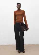 Jersey de punto acanalado color marrón tostado, de cuello alto y manga larga, con ajuste ceñido al cuerpo.