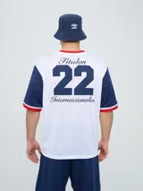 Remera de fútbol Umbro del Club Nacional de Football, de diseño tricolor con cuerpo azul marino, mangas y canesú rojos, y cuello en V con detalles en blanco y azul. Incluye el logo de Umbro en el pecho derecho y el escudo del club en el izquierdo.