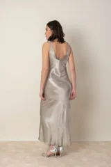 Vestido largo color dorado, de satén, con breteles finos y escote en V.