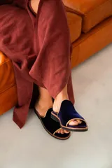 Sandalias de terciopelo azul marino con ribete dorado y plantilla de cuero tostado, de diseño abierto en la punta.
