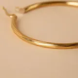 Aros tipo argolla de oro 18k con diseño torneado y acabado brillante.