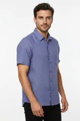 Camisa negra de manga corta, con cuello clásico, cierre frontal con botones y bolsillo ojal en el pecho.