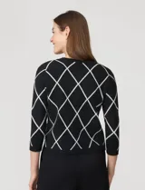 Cardigan tejido negro con estampado de rombos blancos, cuello redondo y cierre frontal con botones dorados. Marca Cable & Gauge.