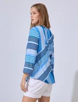 Blusa estampada a rayas azules y blancas, de la marca Ruby Rd. Tiene cuello a la base con escote en V y mangas tres cuartos regulables con presilla y botón.