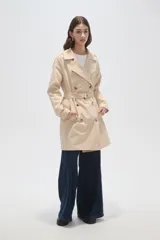 Trinchera de corte clásico con doble botonadura frontal, cuello con solapas, cinturón ajustable en la cintura y bolsillos laterales. Confeccionada en tejido impermeable de poliéster.