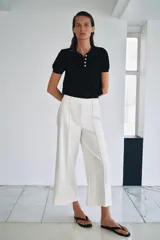 Pantalón cropped de tiro medio color blanco, perteneciente a la colección ZW Collection, con cintura con trabillas, bolsillos laterales ocultos, pinzas en el delantero, pierna ancha y cierre frontal con cremallera, botón y ganchos metálicos.