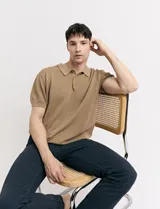 Remera color café de tejido de punto, con cuello polo y mangas cortas.