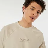 Camiseta beige de manga corta raglán con estampado frontal con el texto "[NXT-K] NO LIMITS, NO HESITATIONS".