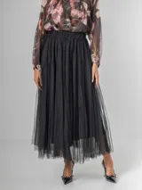 Falda estilo ballet core confeccionada en gasa negra con pequeños destellos que aportan brillo sutil y movimiento. Tiene cintura elastizada.