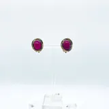 Aros cortos dorados con cristal ovalado color fucsia y ajuste de clip.