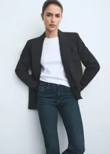 Jeans de tiro medio con diseño flare y bajo deshilachado, confeccionados en tejido elástico de algodón estilo denim. Presentan cinco bolsillos, trabillas y cierre delantero con cremallera y botón.