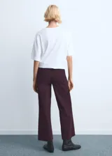 Jeans de corte wide leg y tiro medio, color bordó, con diseño de pernera ancha y terminación sin dobladillo en el bajo.