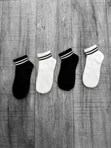 Pack de cuatro pares de medias de algodón, dos pares negros y dos pares blancos, con dos rayas horizontales en el borde superior.