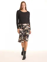 Vestido corto de diseño combinado, marca Moon Maven. La parte superior es una remera negra de manga larga con escote redondo, y se integra a una falda midi estampada con animal print en tonos beige, marrón y negro. Tiene cintura elastizada.