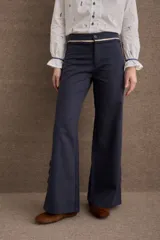 Pantalon de vestir azul marino de corte recto y tiro medio, con detalle de volados en la cintura y cierre frontal con botón.