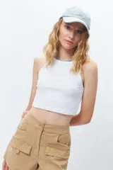 Top corto de tejido acanalado color marrón, con cuello redondo y corte de sisa tipo nadador.