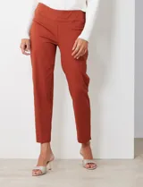 Pantalón de gabardina elastizada color fucsia, de corte recto y pretina ancha pespunteada. Tiene bolsillos simulados.