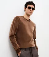Remera de manga larga confeccionada en terciopelo cotelê de poliéster, con cuello redondo y diseño minimalista de corte regular.
