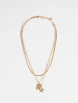 Collar tipo cascada de tres cadenas de eslabones finos en tono dorado, con dos dijes colgantes: uno rectangular con textura irregular y otro en forma de estrella.