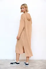 Vestido midi de lanilla color beige con capucha, confeccionado en tejido de punto morley acanalado, de manga larga y silueta holgada.